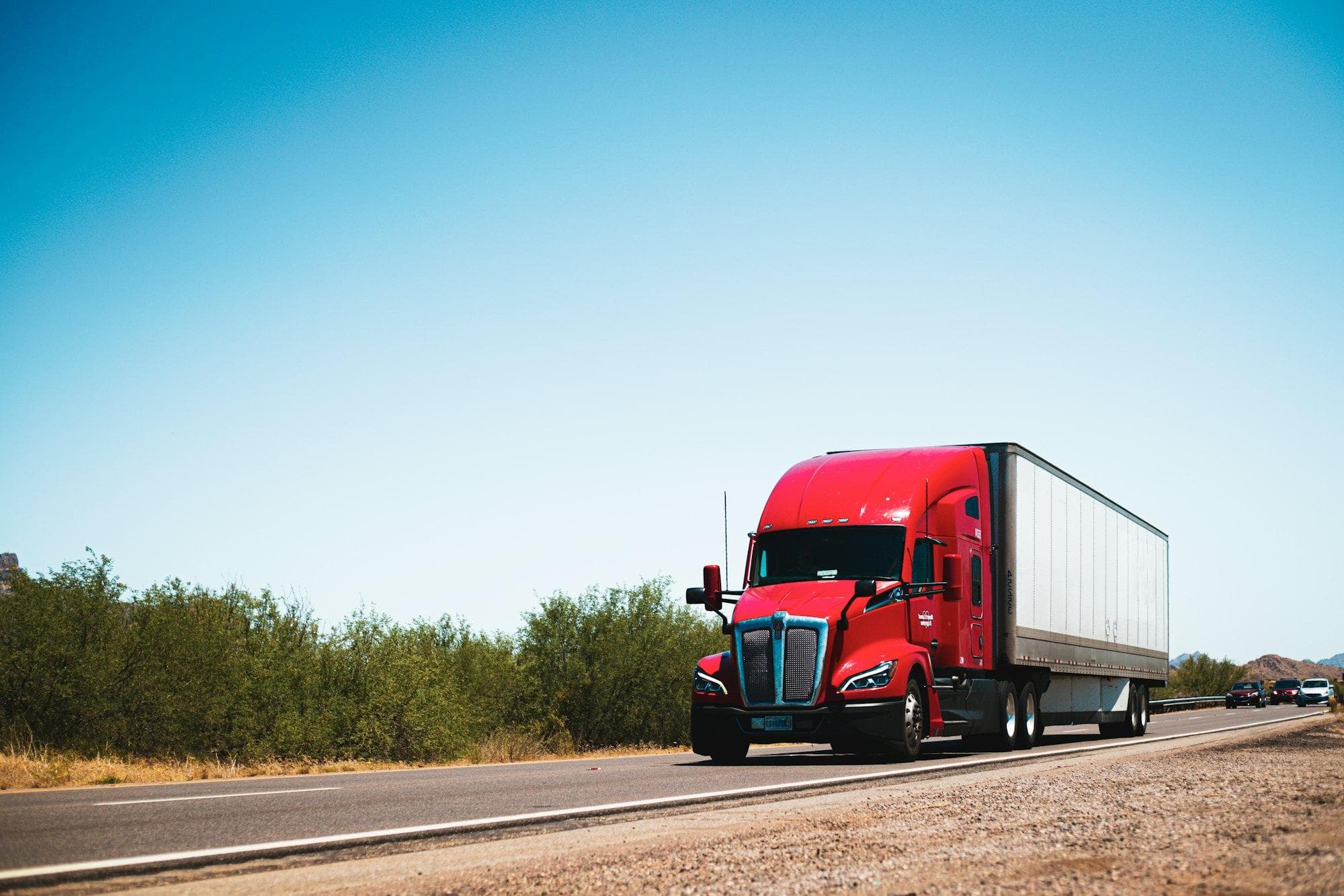 A red semi truck and trailer on an open road