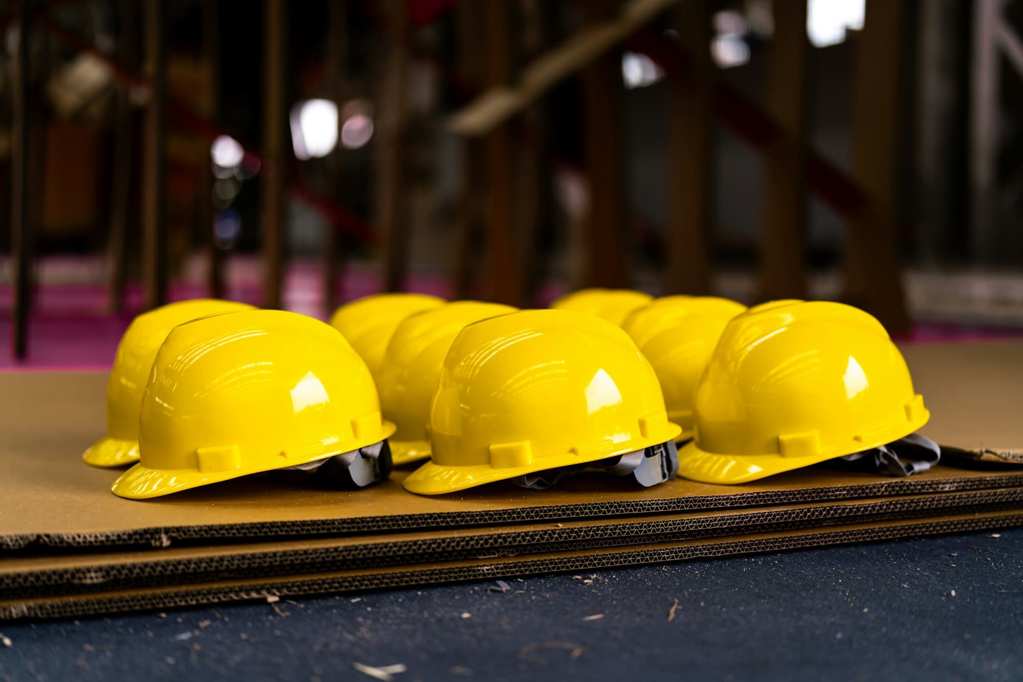 Yellow hard hats lined up on a bench